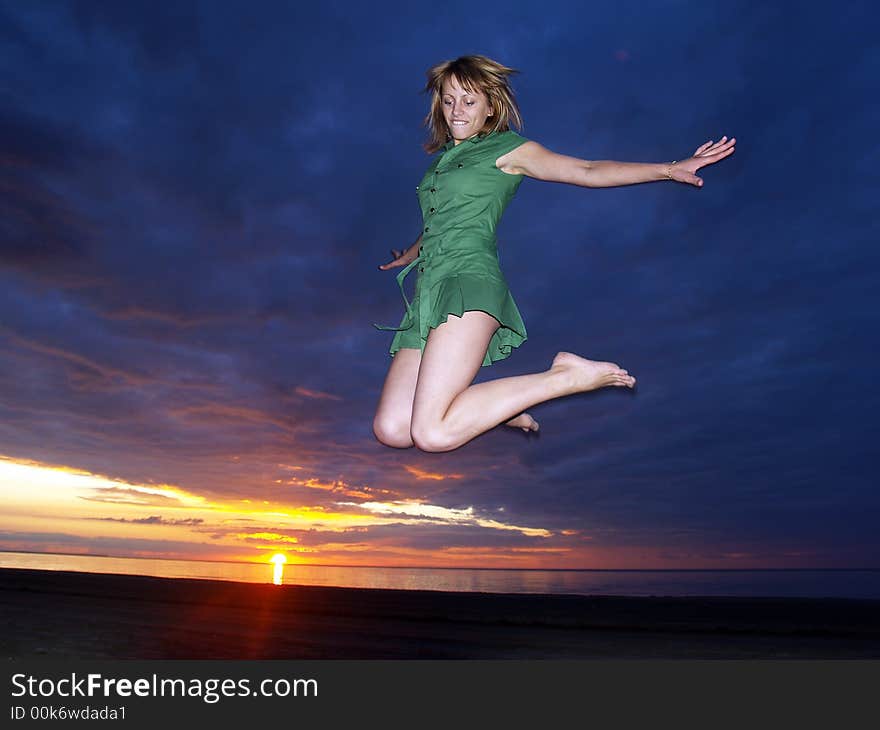 Beautifully girl jumping in sunset