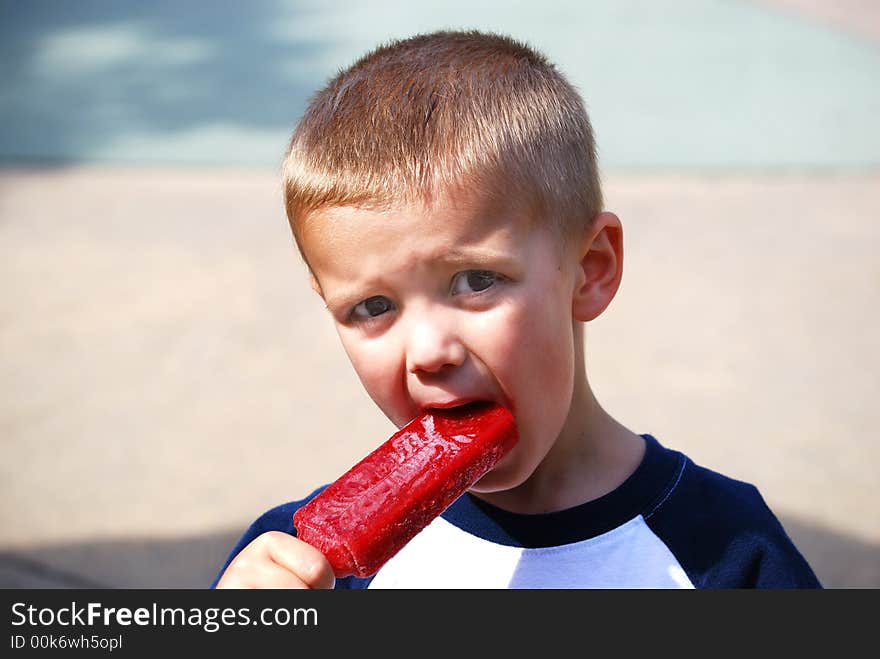 Little boy eating a popsicle. Little boy eating a popsicle