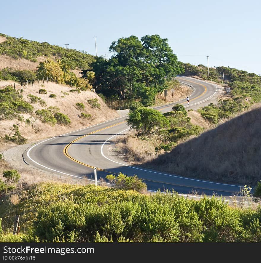 Bicyclist  riding weaving mountain road. Bicyclist  riding weaving mountain road