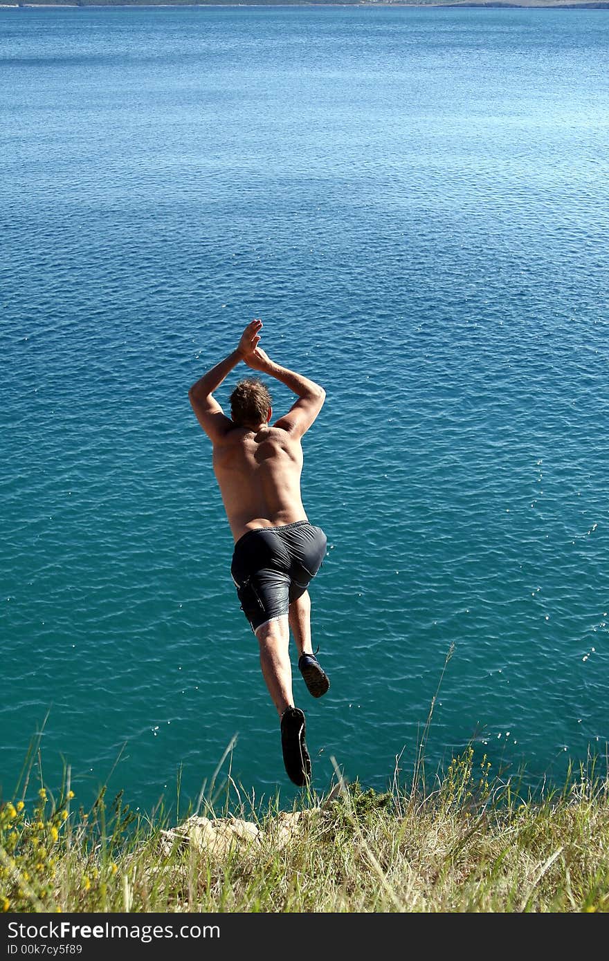 A young man jumps from a cliff into the sea!. A young man jumps from a cliff into the sea!