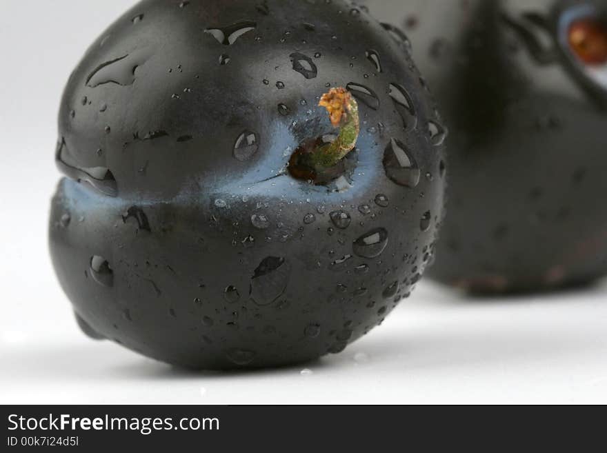 Dewy plums on the white background