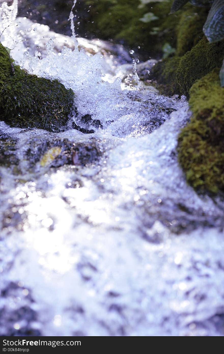 Rushing waterfall between moss covered rocks