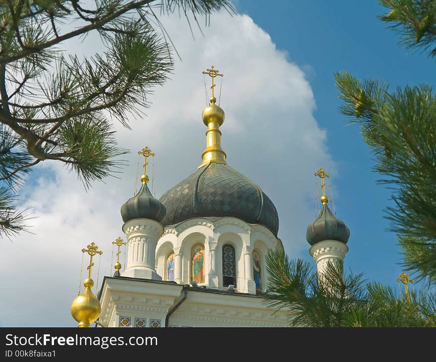 Gold crosses and domes of church, sky and trees