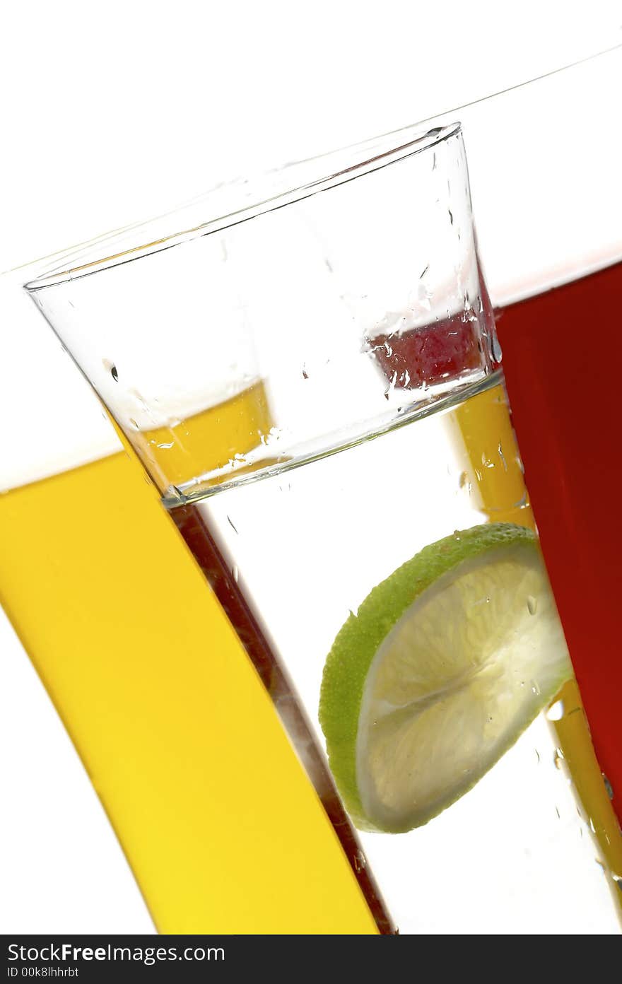 Glasses with juice and lime on the white background