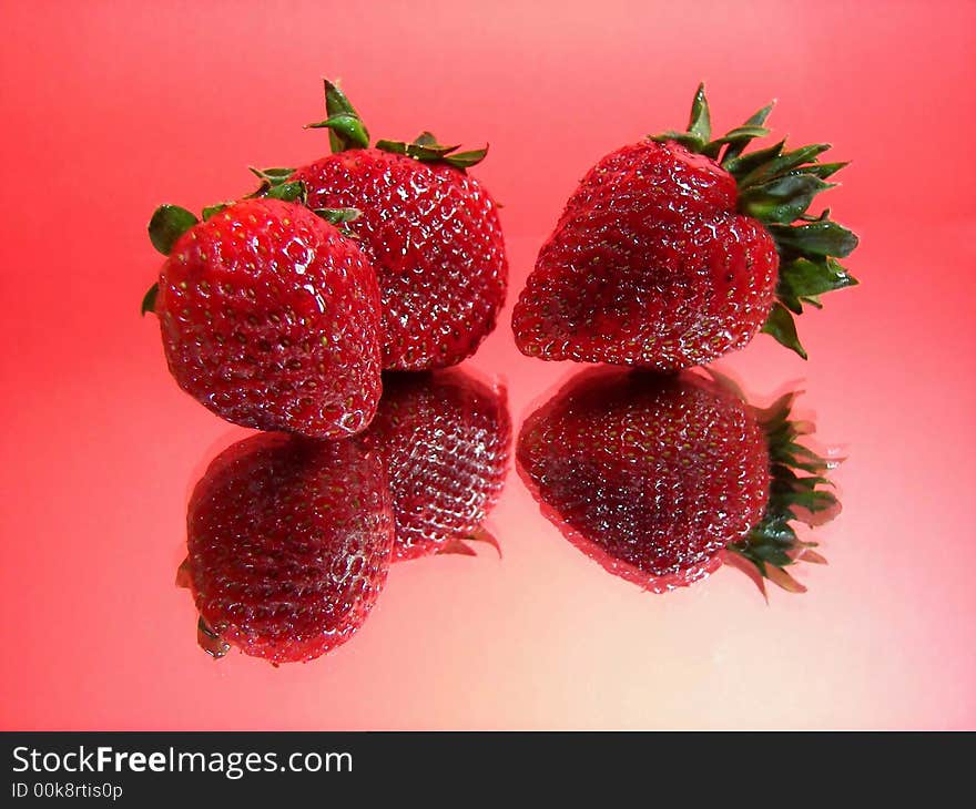 Three strawberries reflected on mirror. Three strawberries reflected on mirror.