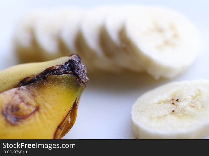 Sliced bananas with skin on white