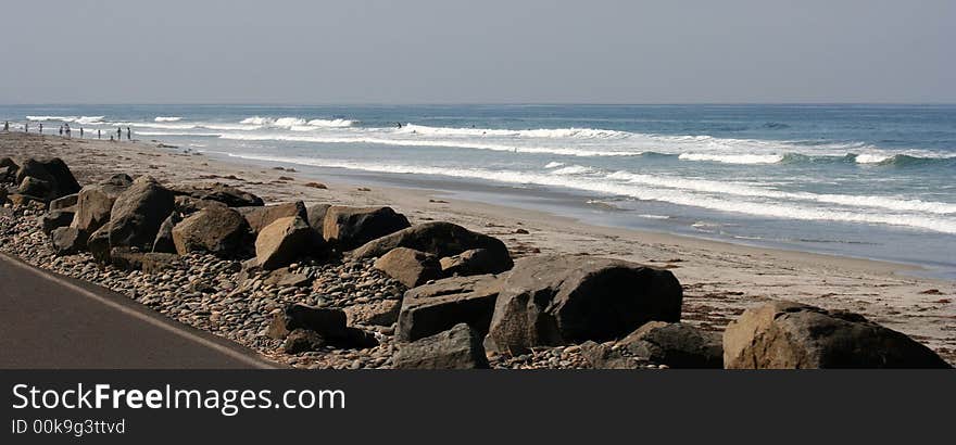 People walking along the beach of the ocean. People walking along the beach of the ocean.