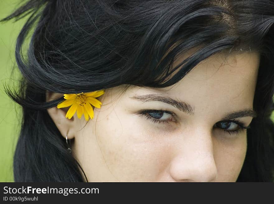 Eyes of a young beautiful brunette girl wearing a flower on hair. Eyes of a young beautiful brunette girl wearing a flower on hair