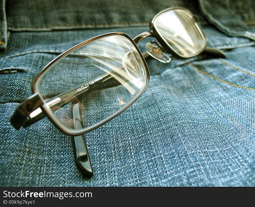 Glasses on a jeans surface. Glasses on a jeans surface