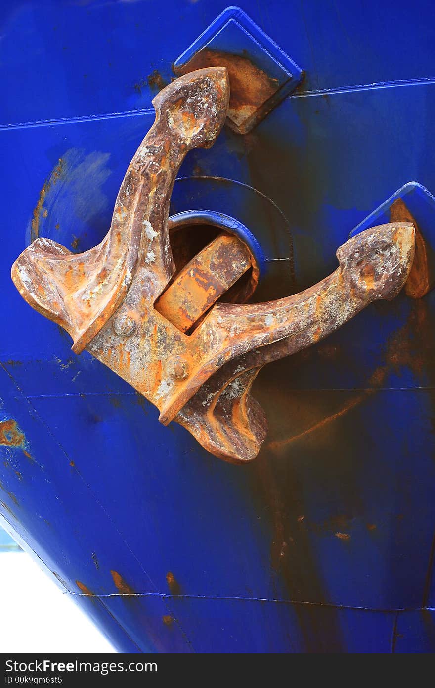 Dirty and rusty old anchor in blue ship