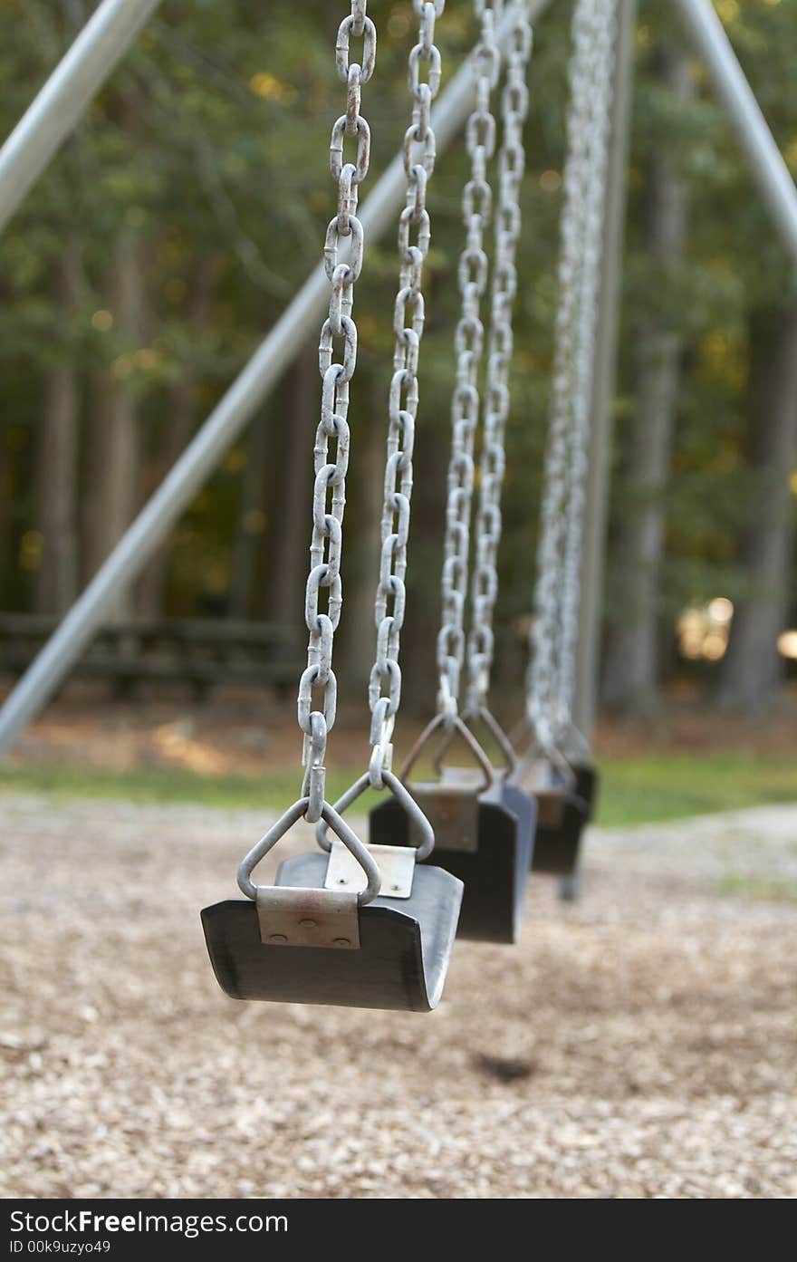 Empty swings in park during daylight. Empty swings in park during daylight