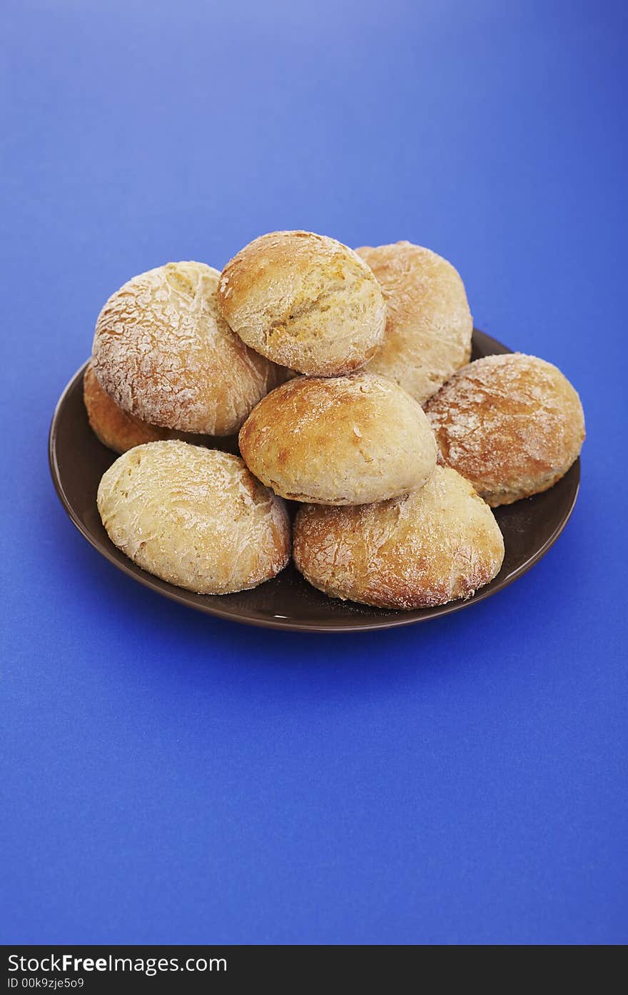 Pile of buns on the plate over blue background