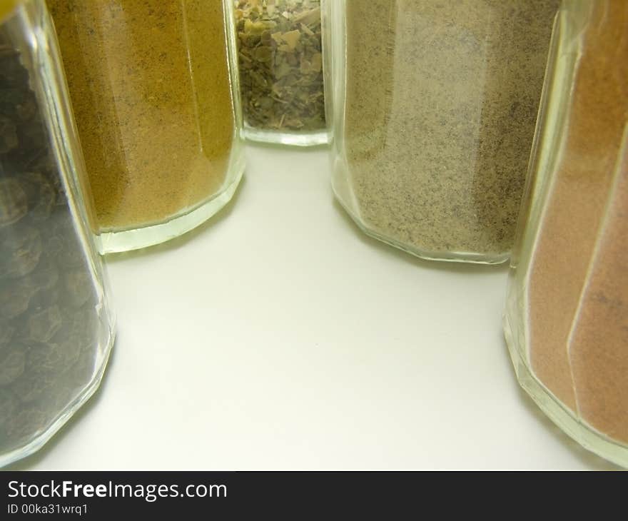 Ground spices in glass tableware and whole black pepper