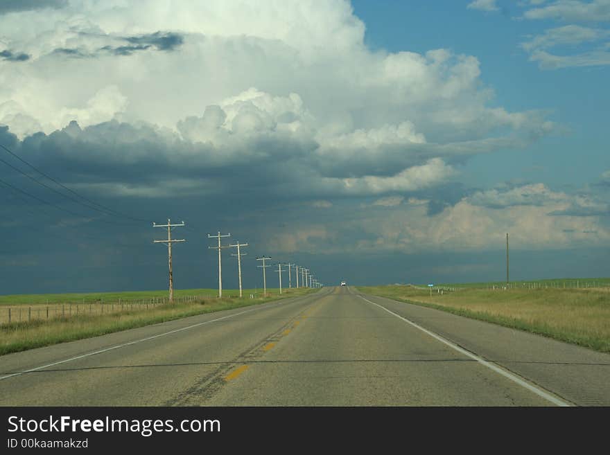 Nature shot of pavement versus cloud riddened sky on well travelled highway. Nature shot of pavement versus cloud riddened sky on well travelled highway