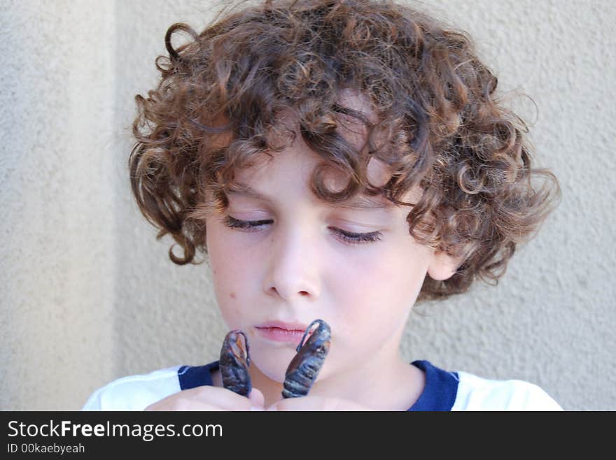 Boy holding a transformed tobacco horn worm, will coccoon for a while untill it turns into a moth. Boy holding a transformed tobacco horn worm, will coccoon for a while untill it turns into a moth