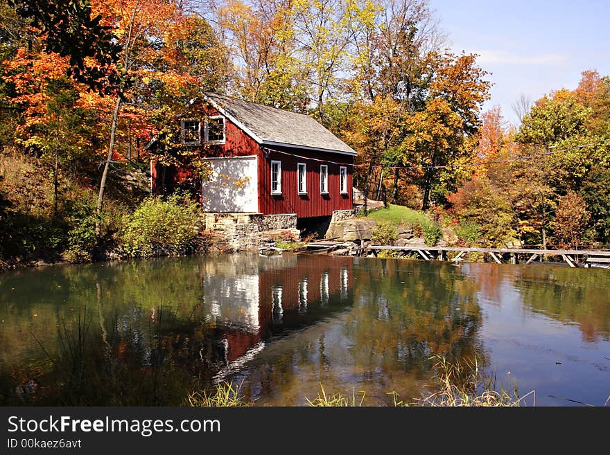 Mill house amongst fall colors with orange and yellow maples and oaks. Mill house amongst fall colors with orange and yellow maples and oaks