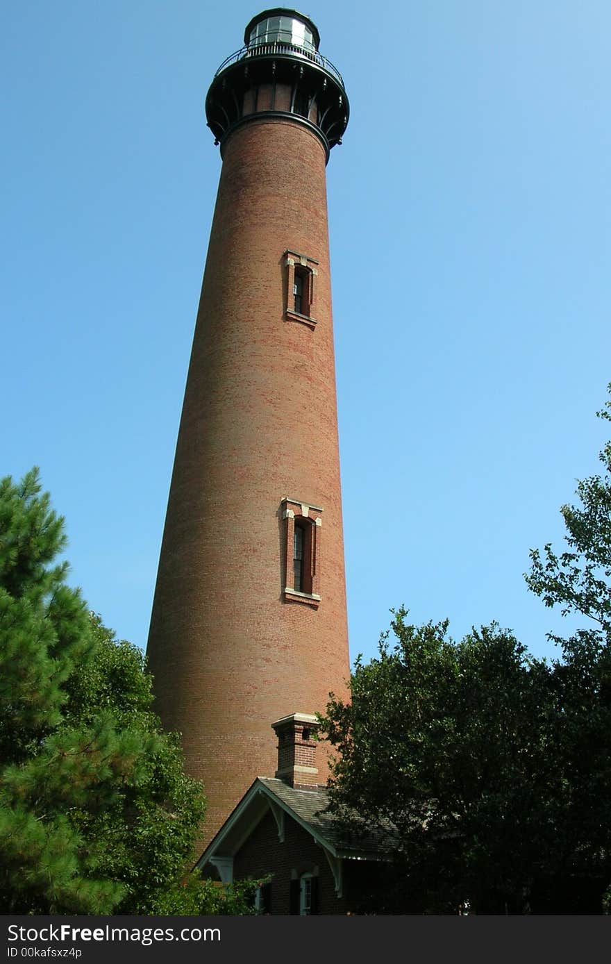 The Currituck Lighthouse on the Outer Banks in North Carolina- against a blue sky.