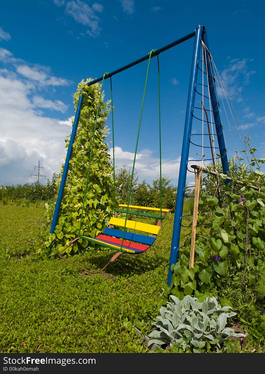 Coloured swing in a small garden. Coloured swing in a small garden