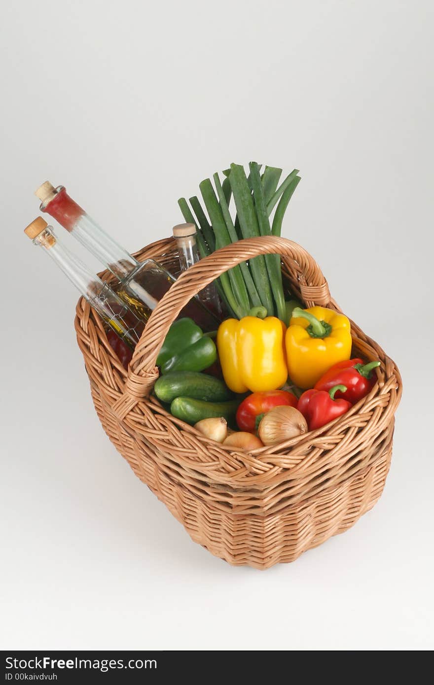 Basket with peppers, cucumbers, onions and oil. Basket with peppers, cucumbers, onions and oil