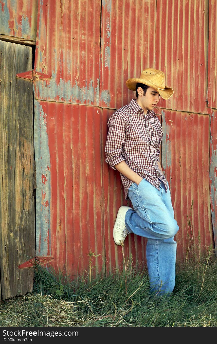 A young cowboy hanging out at the corral. A young cowboy hanging out at the corral