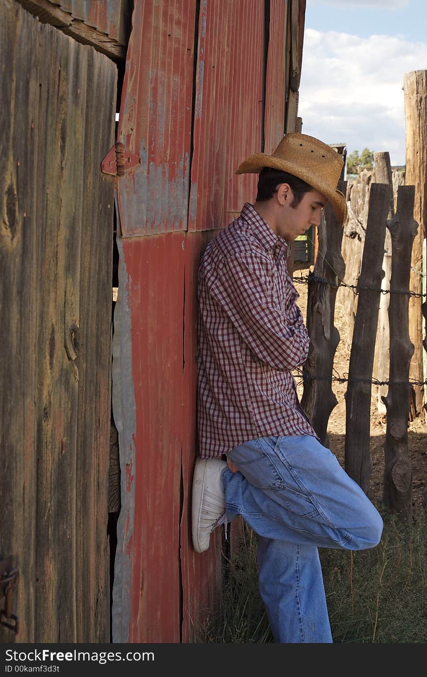 A young cowboy hanging out at the corral. A young cowboy hanging out at the corral