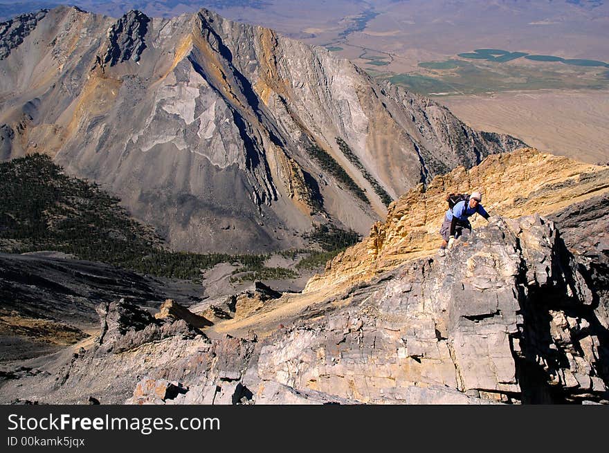 Single person climbing along rocky ridge on a trail. Single person climbing along rocky ridge on a trail