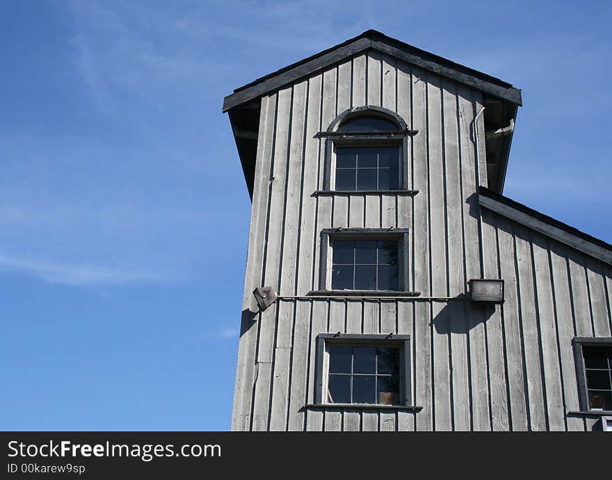 A tower of art studios rises from a gray wooden building.