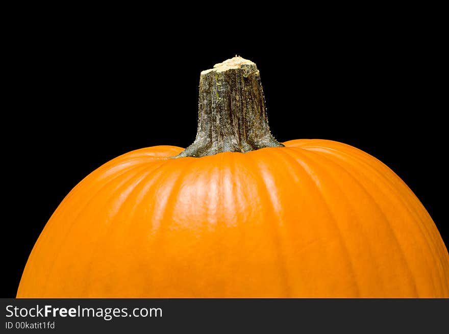 Orange pumpkin with stem on a black background. Orange pumpkin with stem on a black background