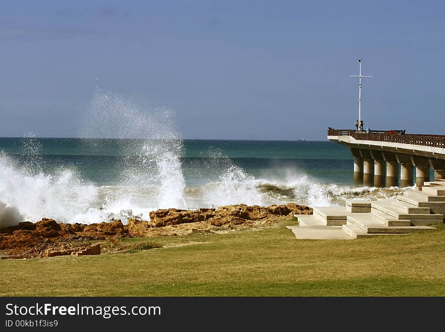 Rough seas and breaking waves next to a pier. Rough seas and breaking waves next to a pier