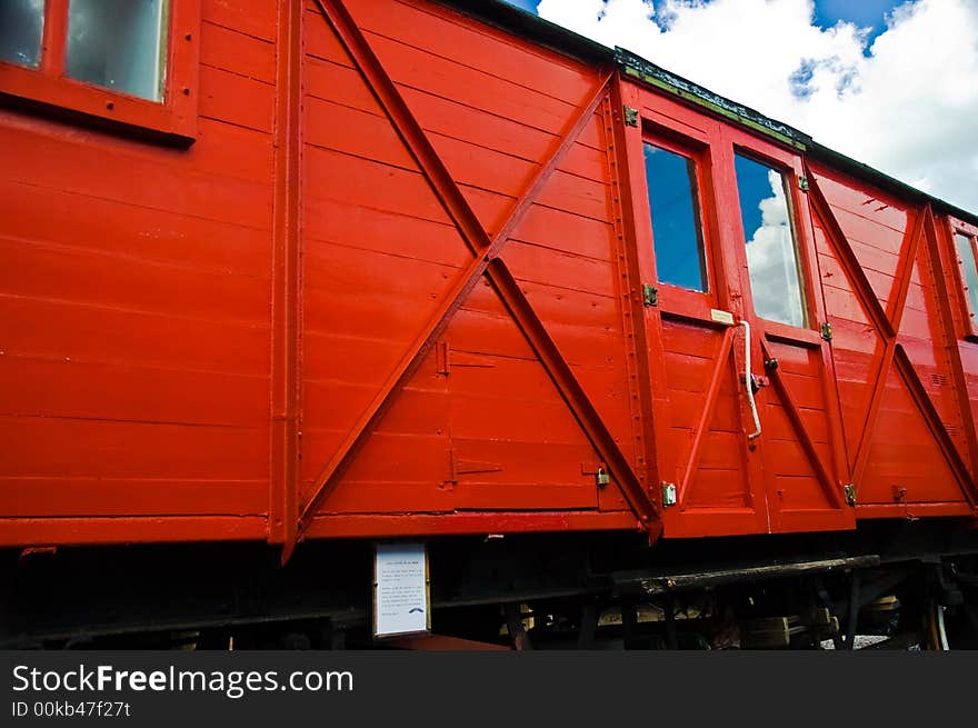 Red railway carriage with reflected blue sky