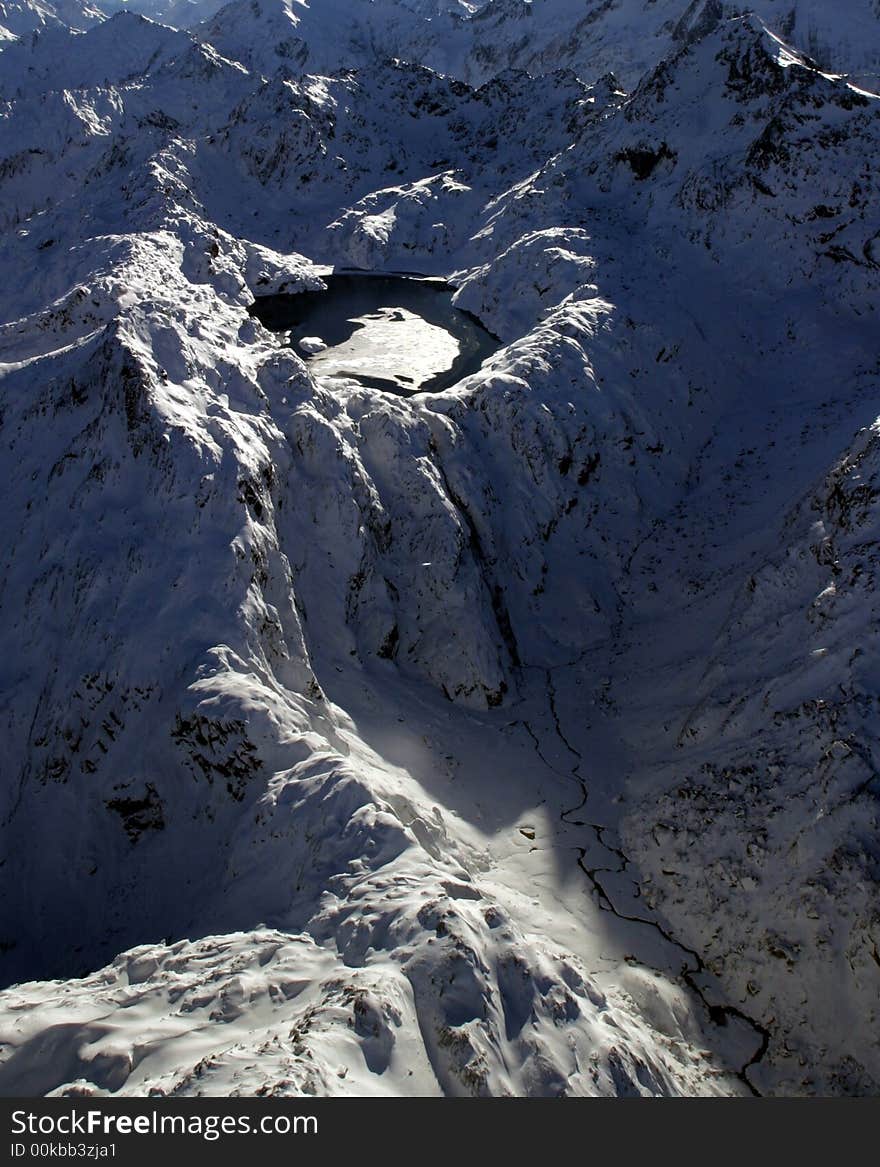 A lake high up in the Southern Alps starts to freeze over at the start of the winter season near Queenstown, South Island, New Zealand. A lake high up in the Southern Alps starts to freeze over at the start of the winter season near Queenstown, South Island, New Zealand