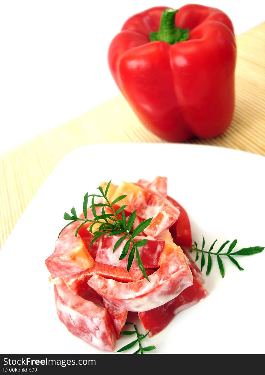 Salad with red pepper on white plate