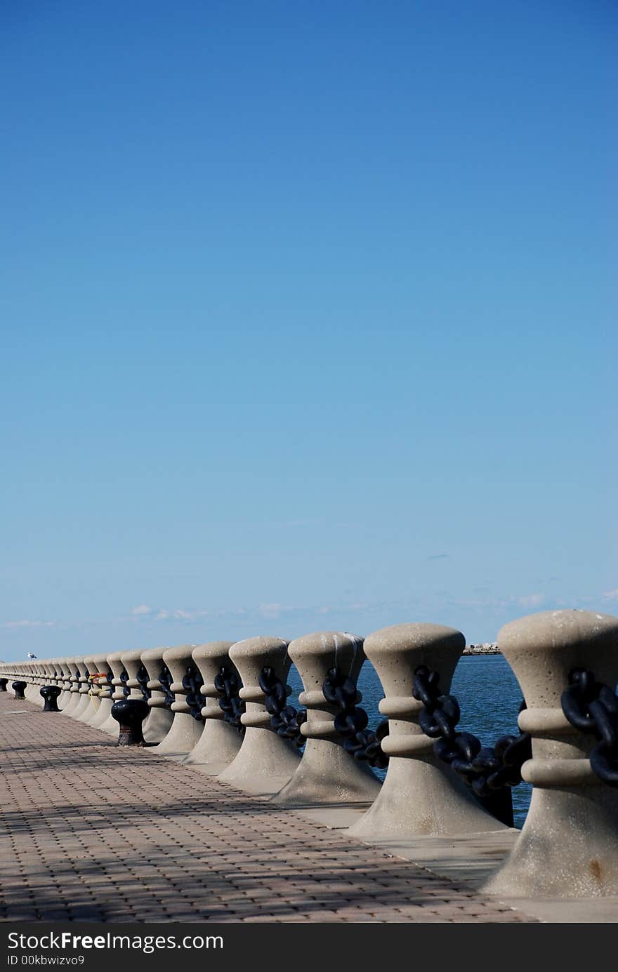 A brick walkway lined with pillars and chains. A brick walkway lined with pillars and chains