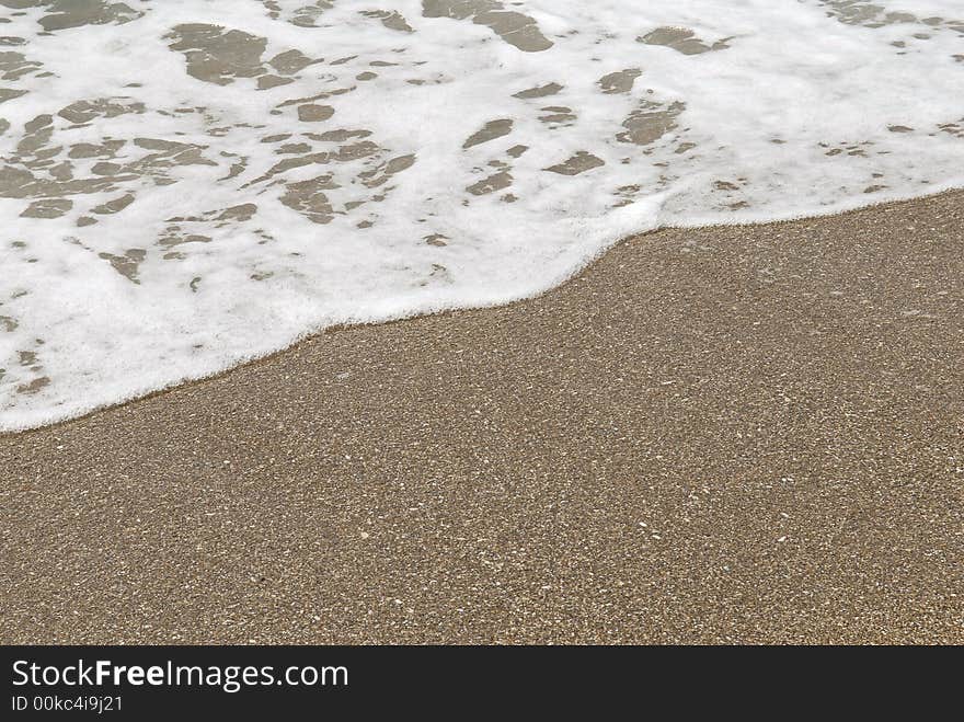 Sea surf on Black sea. Sea sand with a running wave.