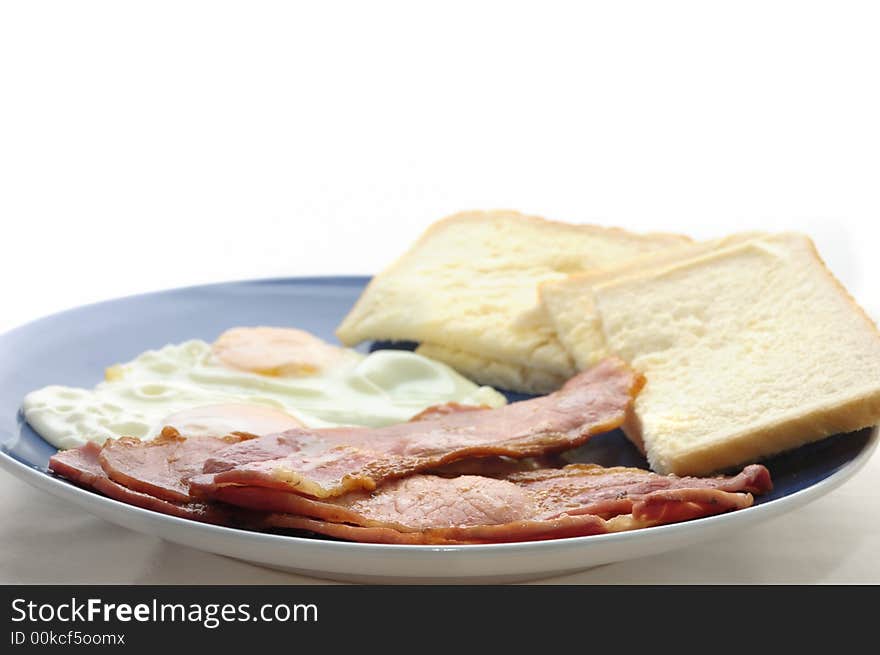 An image of bacon egg with bread and butter on a blue plate. An image of bacon egg with bread and butter on a blue plate