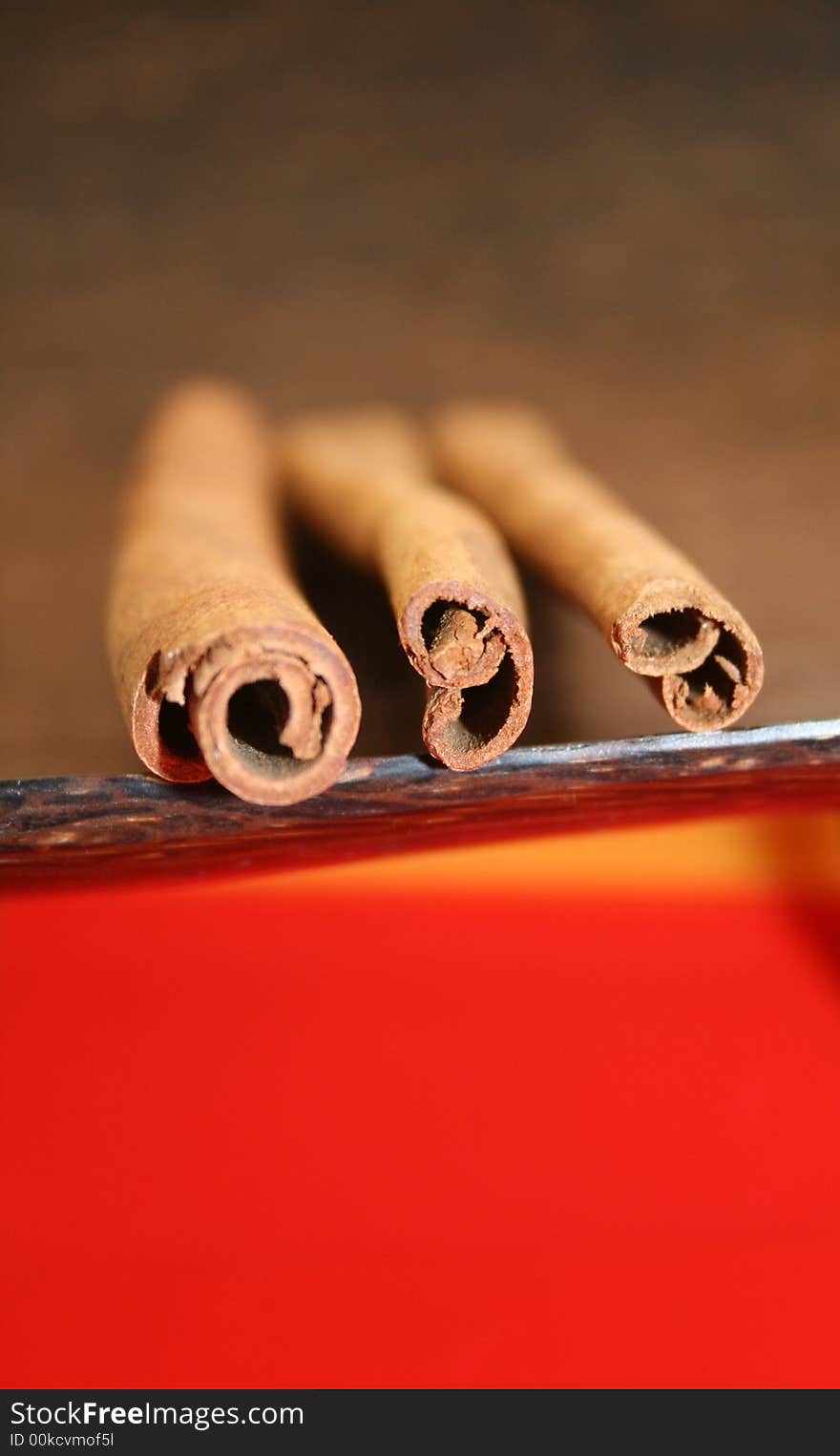 Three cinnamon sticks on the wooden plate