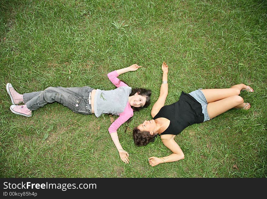 Mother and daughter-teenager lie on the grass