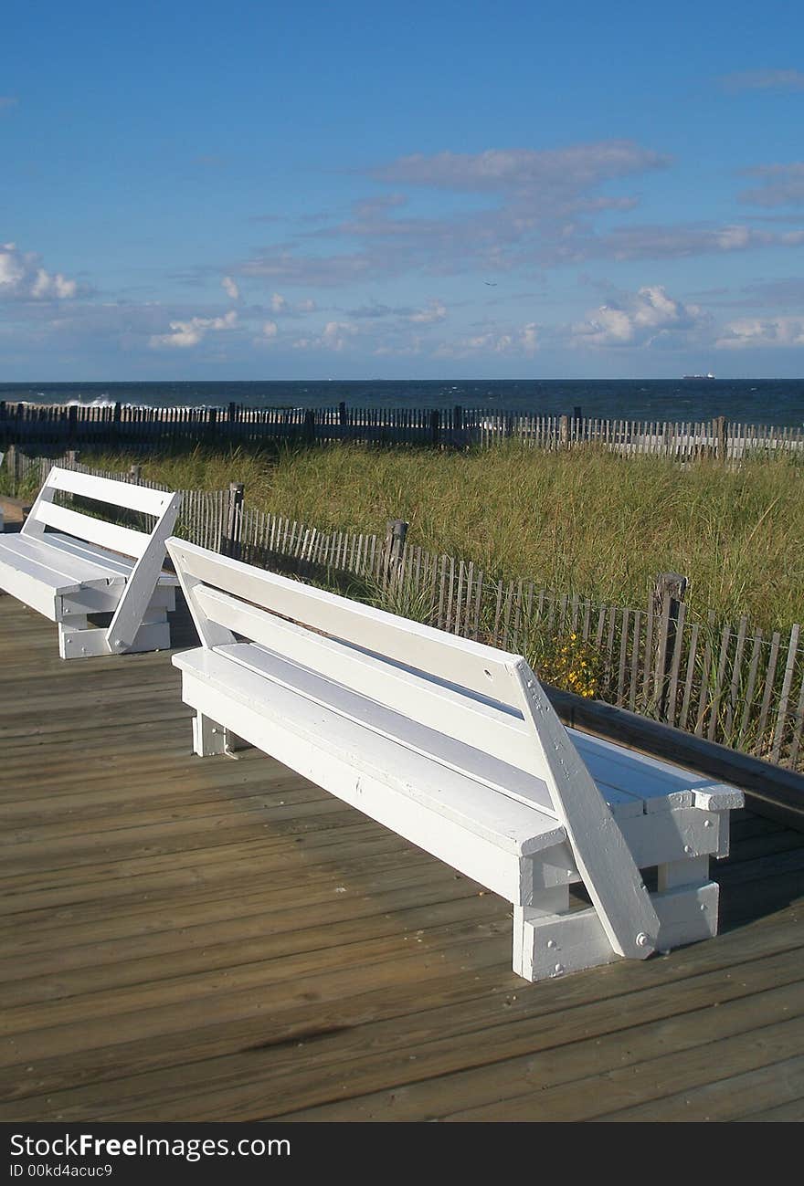 Two benches on the boardwalk off the beach