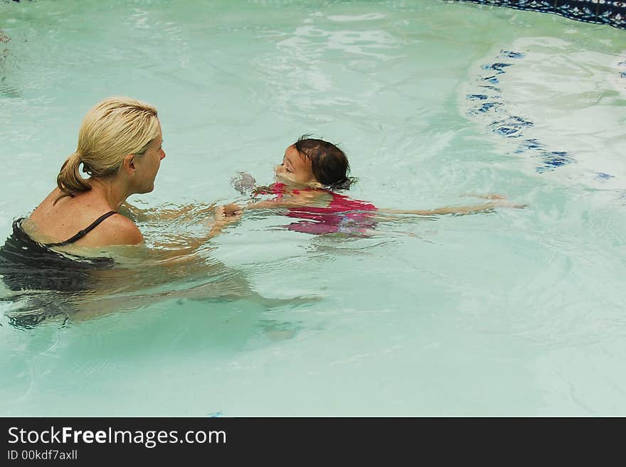 A baby girl at swimming lessons.