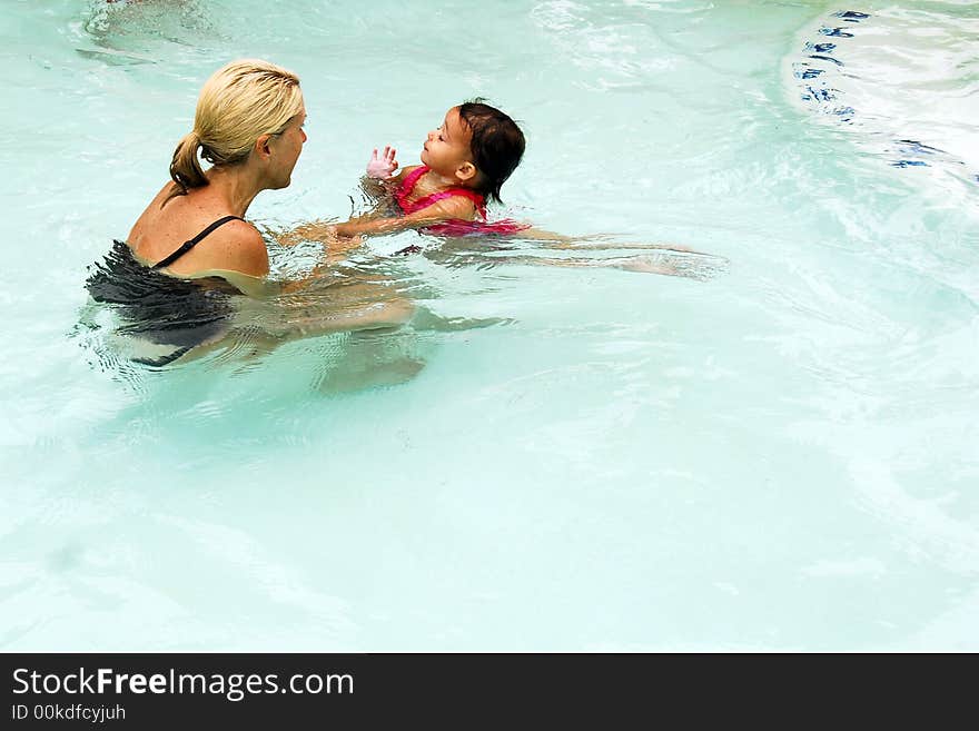 A baby girl at swimming lessons.