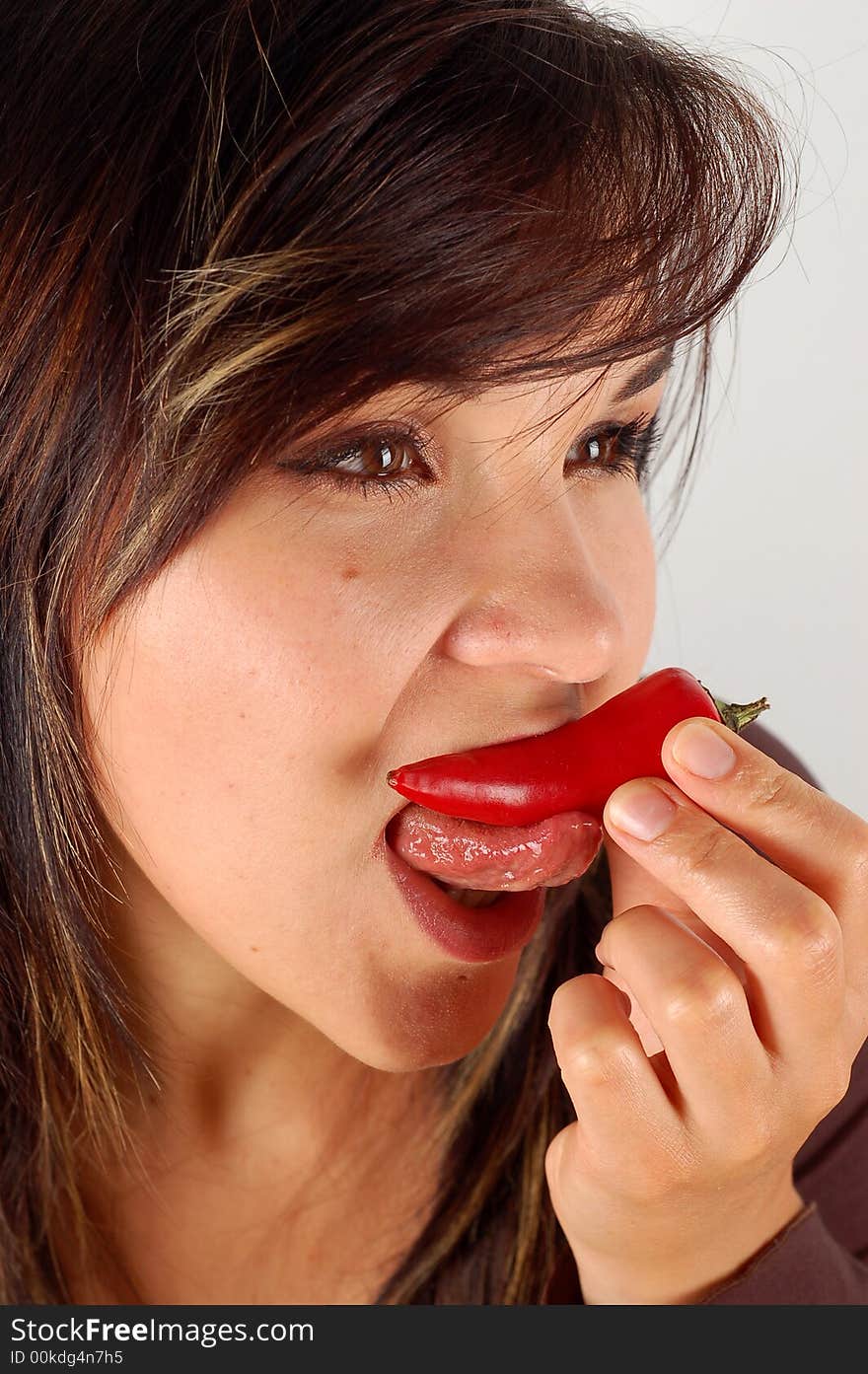 Woman eating red pepper