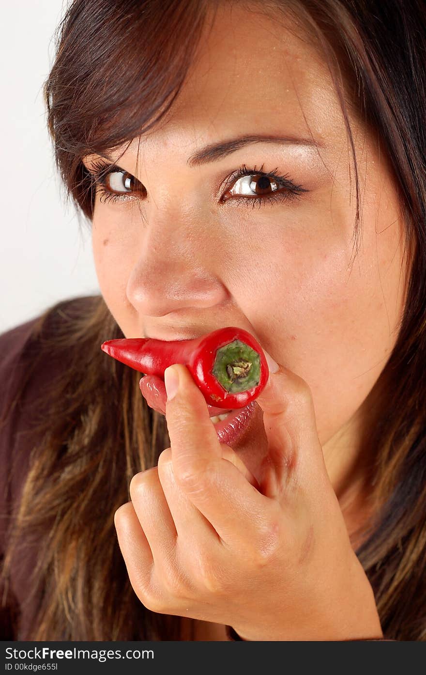 Woman eating red pepper