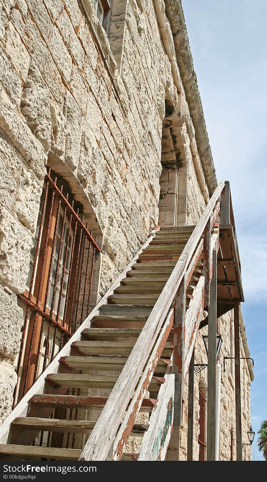 An old wooden staircase ascending a stone fortress. An old wooden staircase ascending a stone fortress