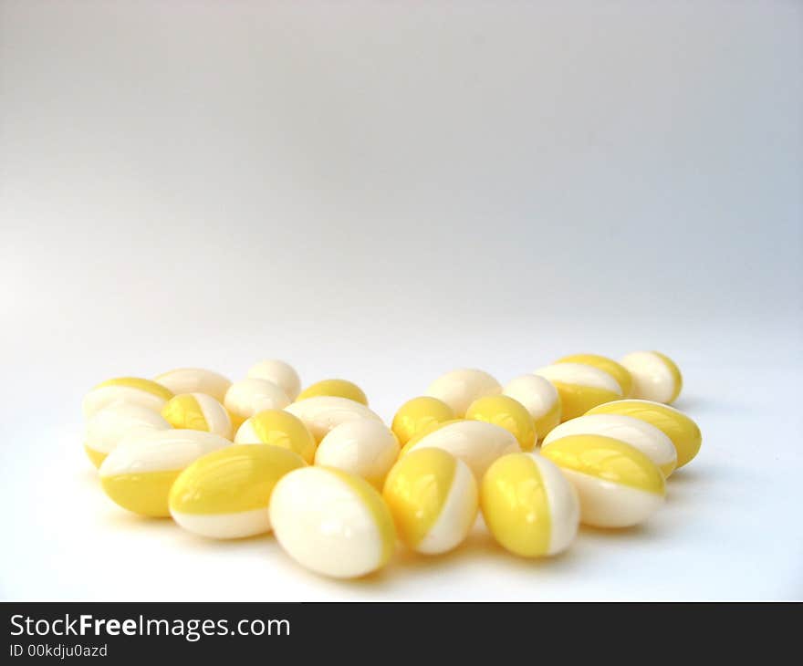 White and yellow pills on a white background