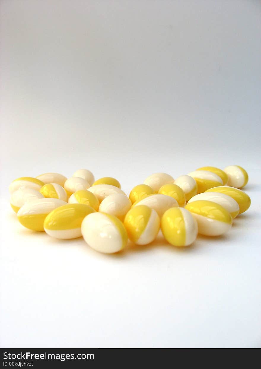 White and yellow pills on a white background