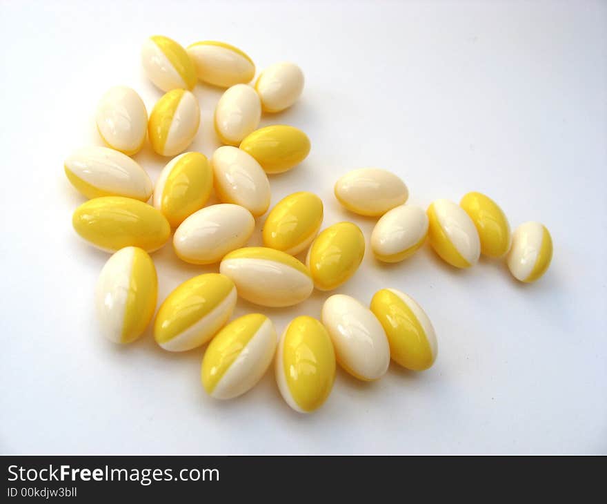 White and yellow pills on a white background