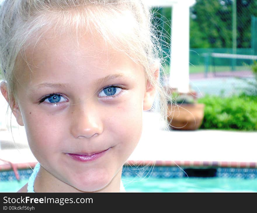 A cute child with long blonde hair and big baby blue eyes wearing a tropical print dress. A cute child with long blonde hair and big baby blue eyes wearing a tropical print dress.