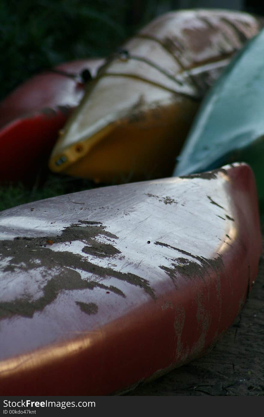 Four kayaks laying near a boat dock in Provincetown, MA.