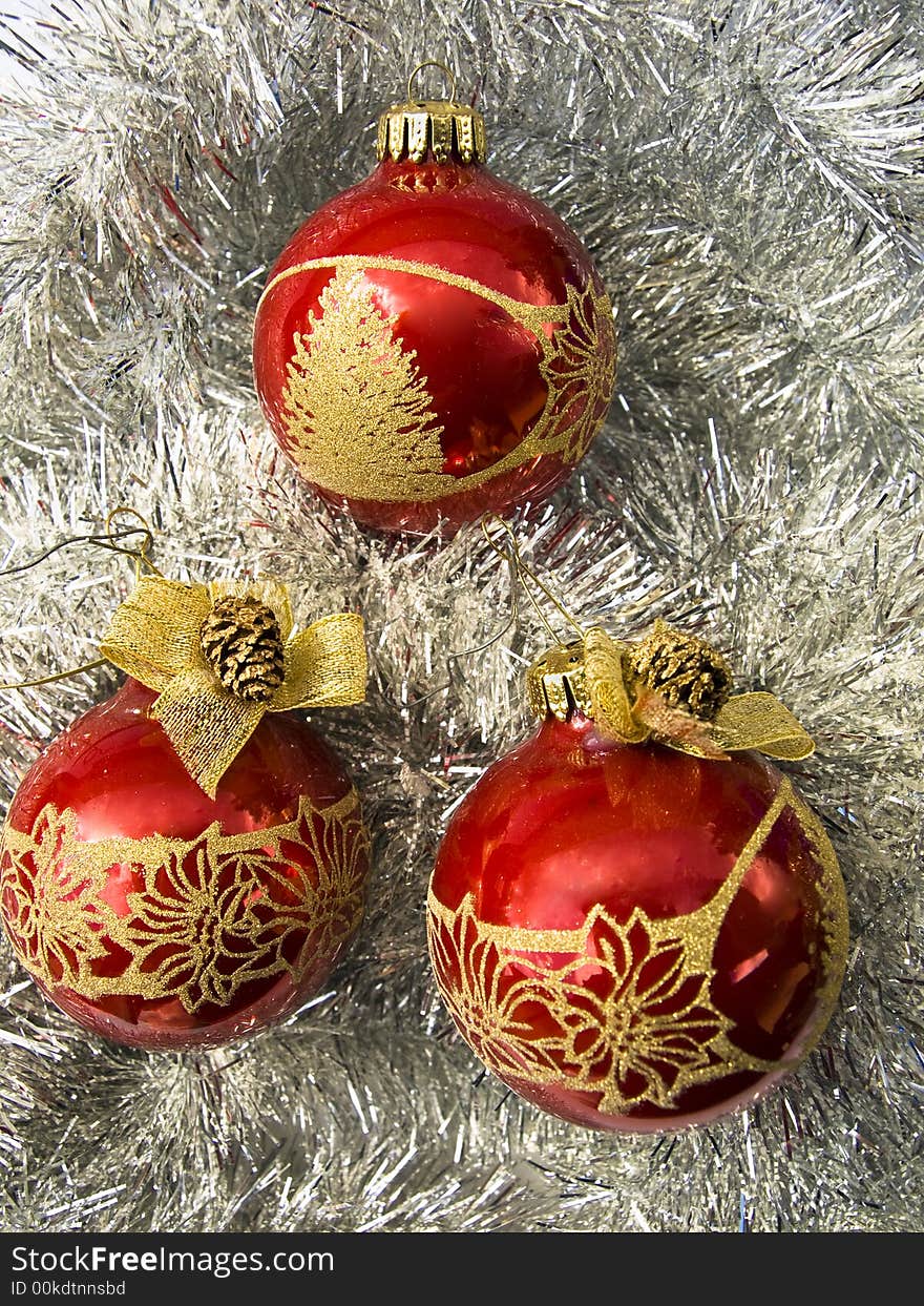 Three red Christmass balls with golden decor on a silver decoration. Three red Christmass balls with golden decor on a silver decoration