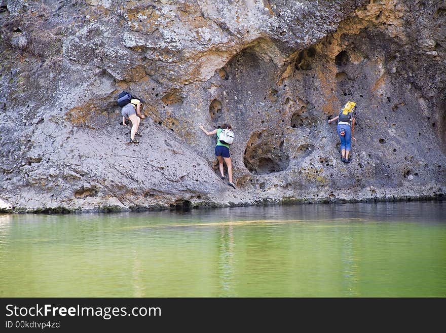 Climbers traversing rockwall